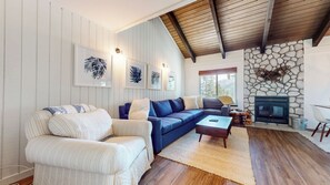 A living room with a sofa, armchair, fireplace, and framed artwork. - Upgraded spacious corner unit, close to Canyon Lodge, Village Lakes Basin (Mammoth Lakes)