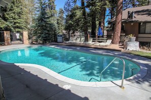 Ein Schwimmbecken mit Liegestühlen und einer Holzterrasse.