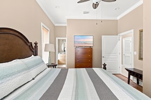 A bedroom with a bed, a dresser, a television, and a door. - Krusty Krab | Sleeps 10 |  Bay Views Pet-Friendly (Gulf Shores)