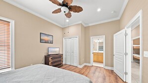 A bedroom with a bed, a dresser, a ceiling fan, and a closet. - Krusty Krab | Sleeps 10 |  Bay Views Pet-Friendly (Gulf Shores)