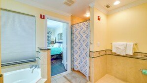 A bathroom with a bathtub, shower curtain, and tiled walls. - Extended-stay Condo in Reunion Golf Resort (Kissimmee)