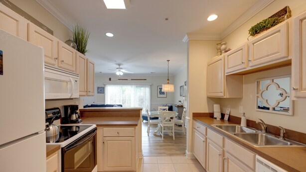 A modern kitchen with a central island, built-in appliances, and a dining area in the background. - Condo w/ Pools! 5 Mi to Broadway at the Beach (Myrtle Beach)