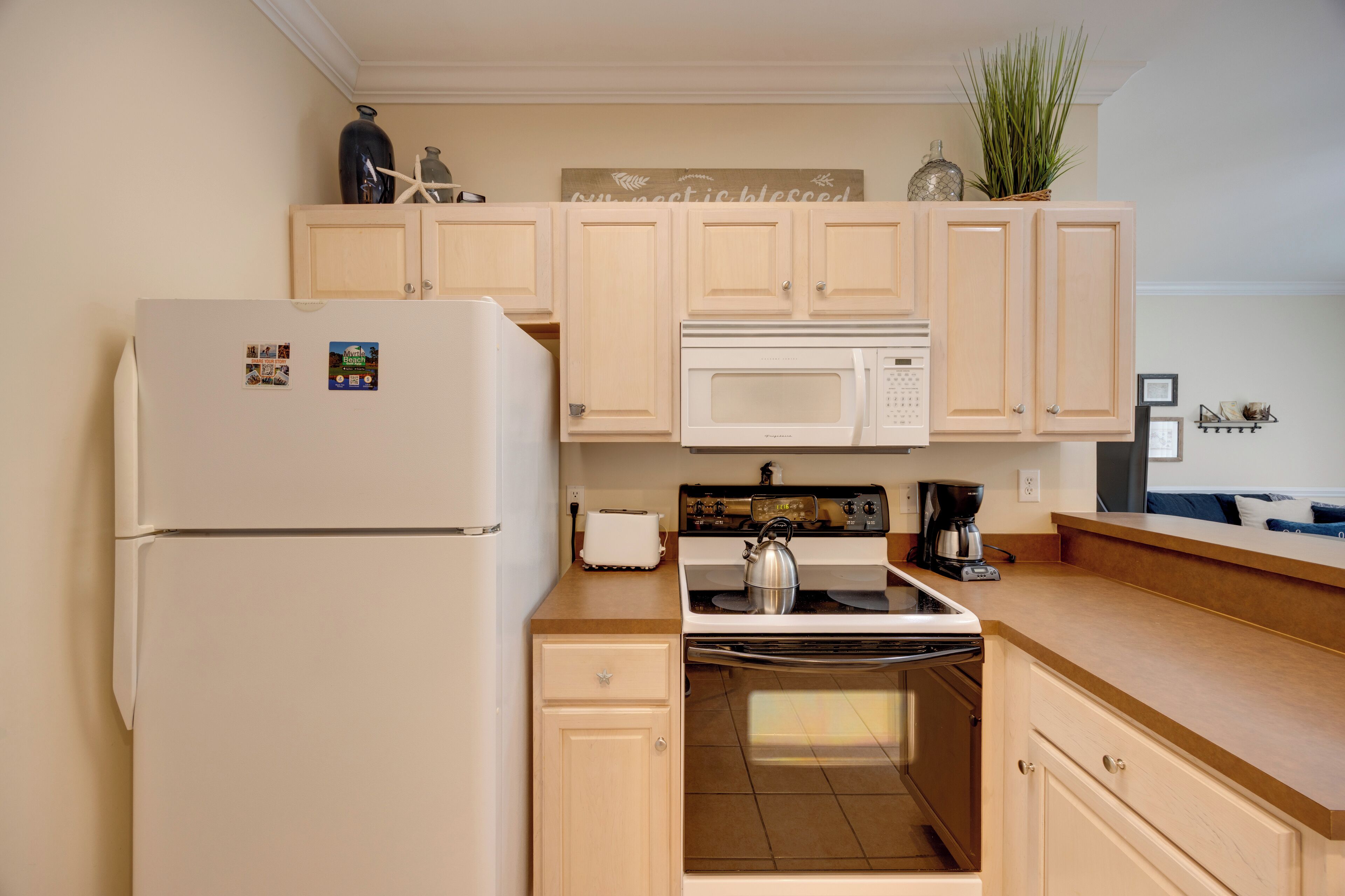 A kitchen with a refrigerator, microwave, stove, and oven.