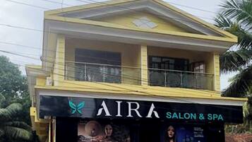Un bâtiment à deux étages, avec une enseigne indiquant « AIRA SALON & SPA » au rez-de-chaussée.