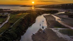 Ein Fluss mit Booten, eine Straße und ein Sonnenuntergang.