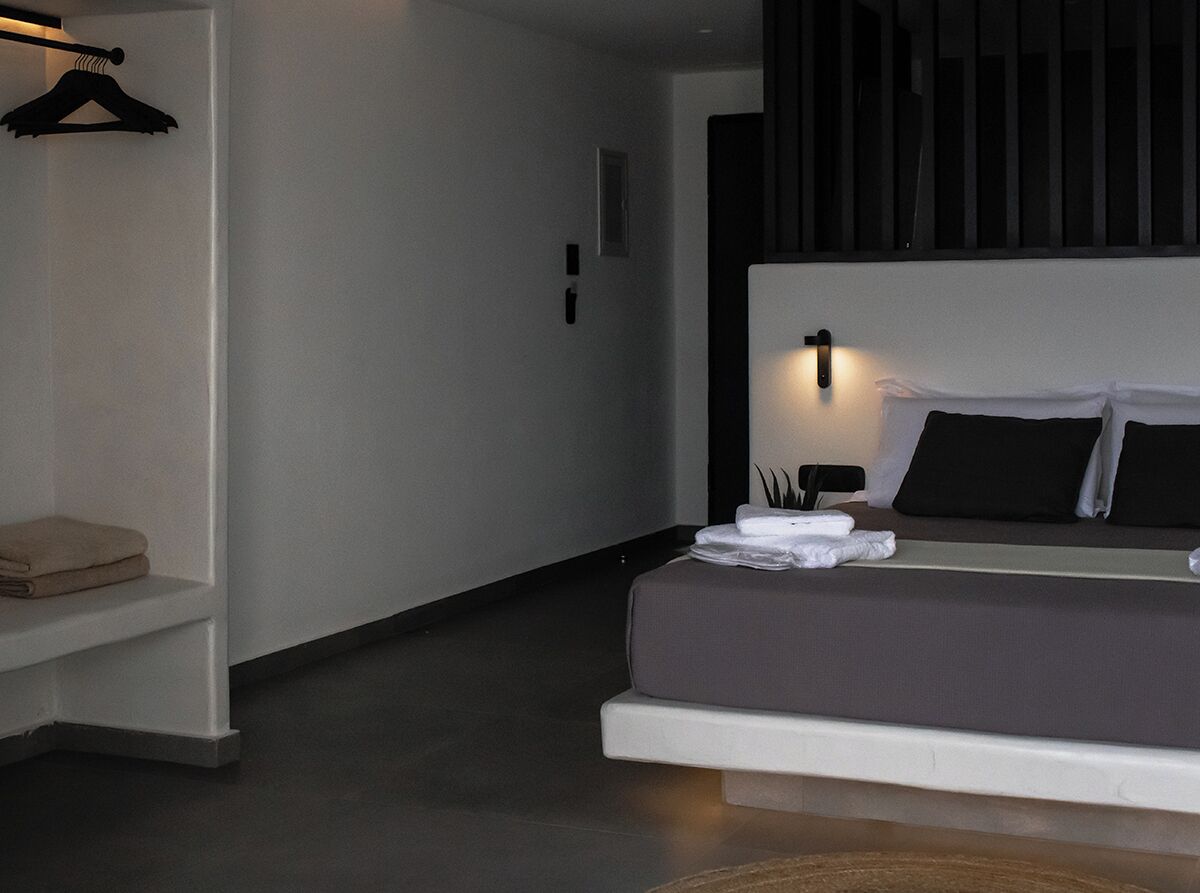 Ein modernes Schlafzimmer mit Bett, Nachttisch und einer Kleiderstange.