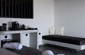 Une chambre moderne avec un lit, une table de chevet et une machine à café.