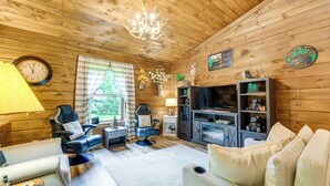 A wooden interior with a sofa, armchair, television, fireplace, and a clock. - Great for Elk Viewing! Creekside Maggie Valley Gem (Maggie Valley)