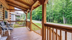 A wooden deck with chairs and a table, overlooking a forested area. - Great for Elk Viewing! Creekside Maggie Valley Gem (Maggie Valley)
