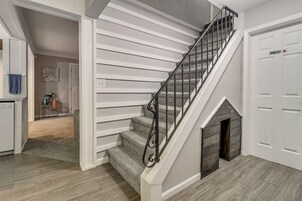 Una escalera con barandilla metálica, una chimenea y una puerta que indica 'Master Suite'.