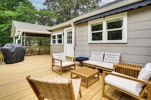 A deck with outdoor furniture, a covered area, and a building with windows. - 2 Mi to UNC Campus! Quiet Escape w/ Deck & Grill (Carrboro)