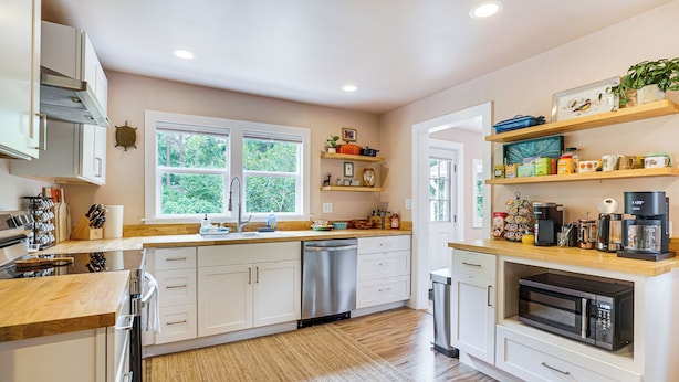 A modern kitchen with white cabinetry, a stainless steel dishwasher, and a built-in microwave. - 2 Mi to UNC Campus! Quiet Escape w/ Deck & Grill (Carrboro)