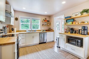 A modern kitchen with white cabinetry, a stainless steel dishwasher, and a built-in microwave. - 2 Mi to UNC Campus! Quiet Escape w/ Deck & Grill (Carrboro)