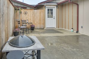 A patio area with a grill, chairs, and a door. - 2-unit Family Combo, Walk to Downtown Sequim! (Sequim)
