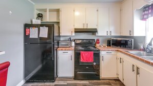 A kitchen with a refrigerator, stove, microwave, and cabinets. - 1 Mi to Dtwn! Quaint Vidalia Getaway w/ Patio (Vidalia)