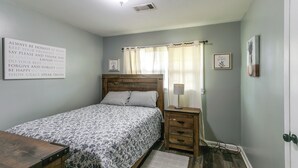 A bedroom with a bed, bedside table, lamp, and a motivational quote on the wall. - 1 Mi to Dtwn! Quaint Vidalia Getaway w/ Patio (Vidalia)