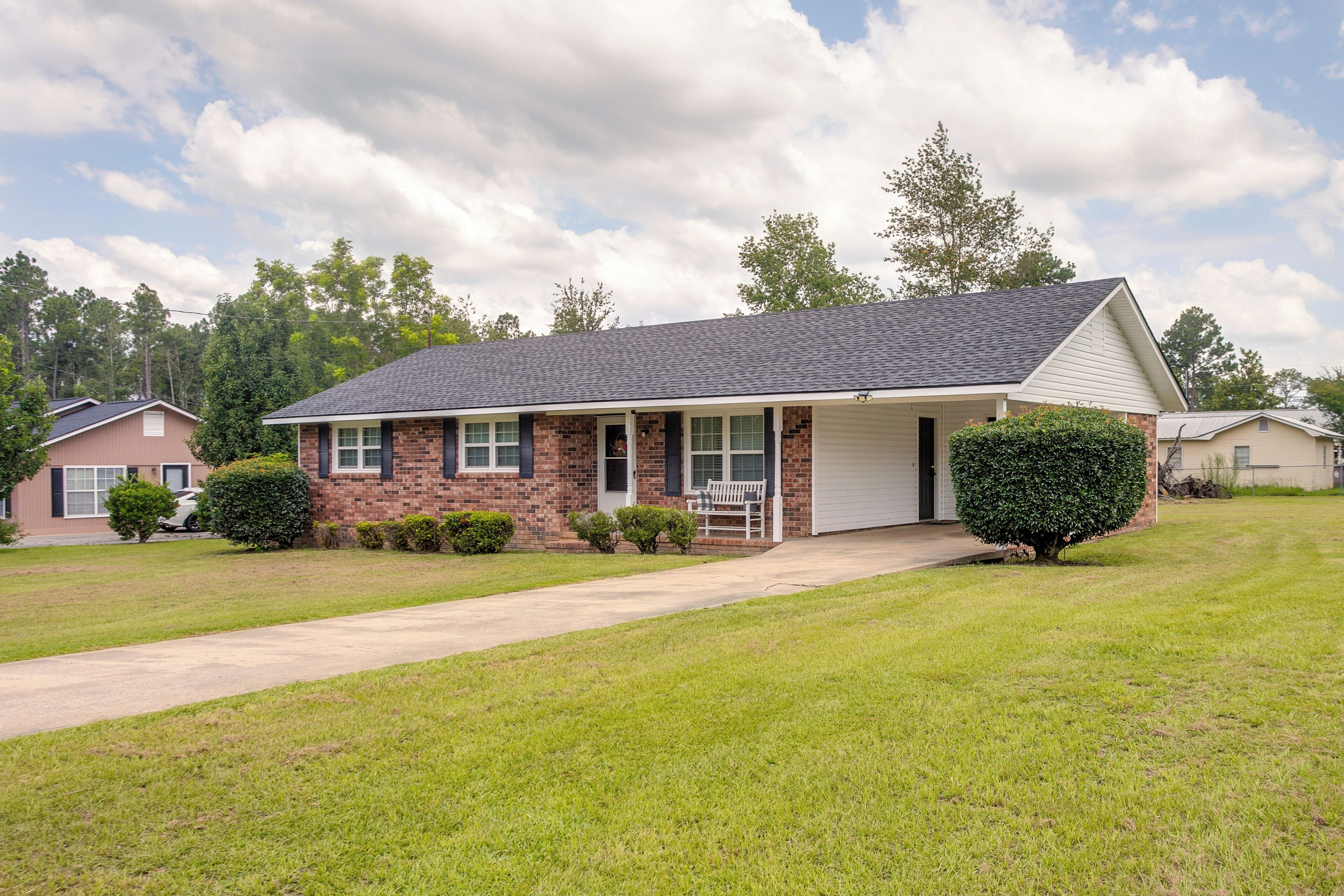 A single-story house with a front porch, a garage, and a well-maintained lawn.