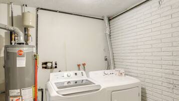 A laundry room with a water heater, washing machine, and dryer.