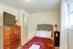 A bedroom with a bed, dresser, television, and a door. - Explore Oberlin! Home 1 Mi to Main Street & Campus (Oberlin)