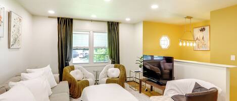 A modern living room with a sofa set, a TV, and a dining area.