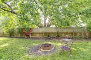 A backyard with a hammock, a fire pit, and a table with chairs. - Explore Oberlin! Home 1 Mi to Main Street & Campus (Oberlin)