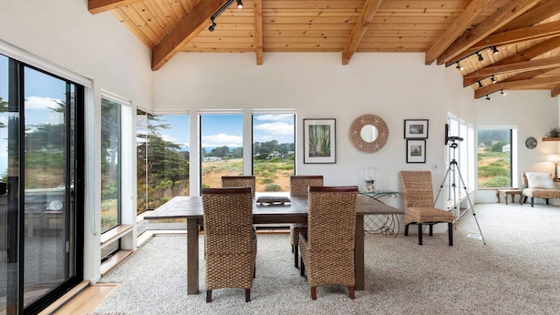 A dining area with a wooden ceiling, large windows, and a view of the outdoors. - Crows Nest TOT #1952 (The Sea Ranch)