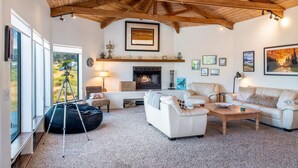 A spacious living room with a fireplace, white sofas, a coffee table, and a bean bag. - Crows Nest TOT #1952 (The Sea Ranch)