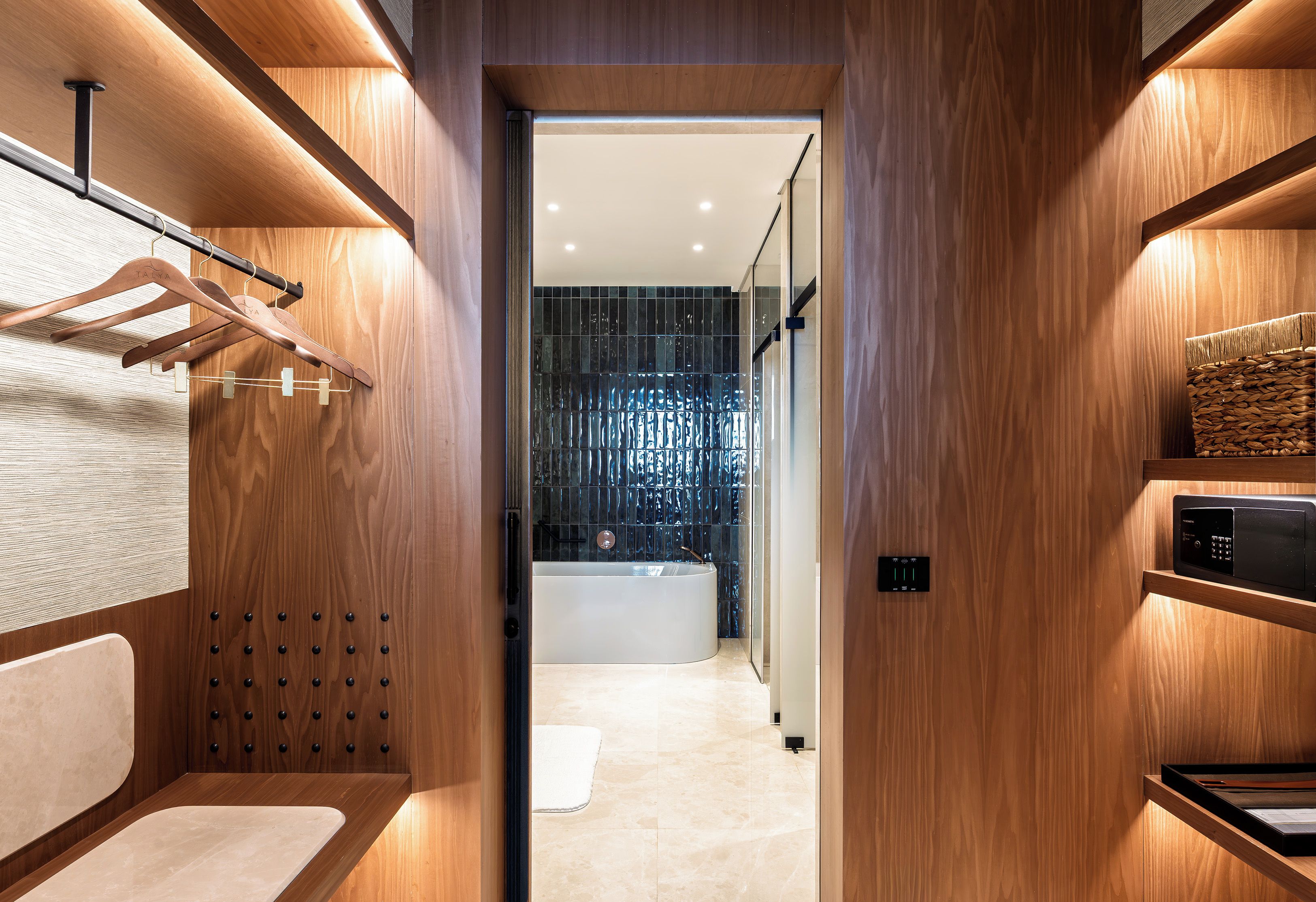 Een moderne badkamer met een houten wastafelmeubel, een handdoekrek en een bad.