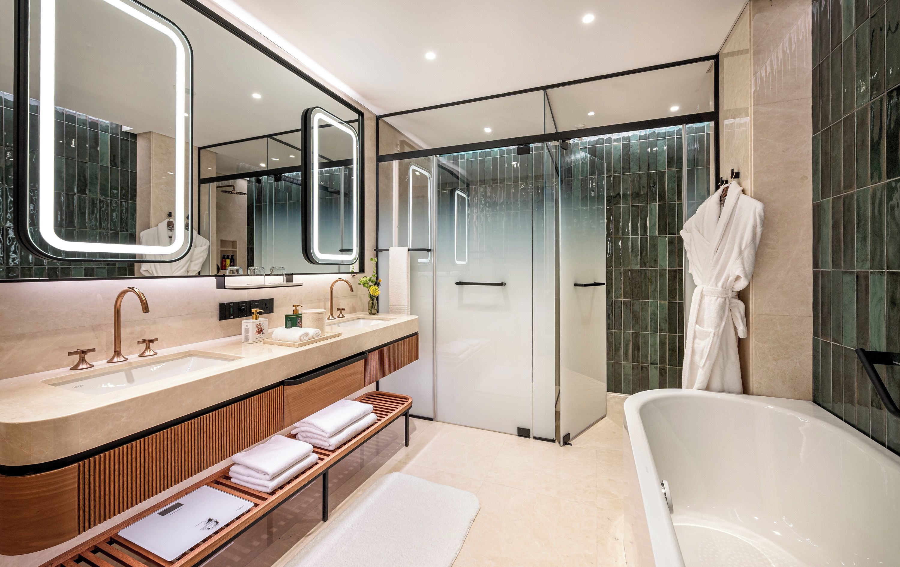 A modern bathroom with a large bathtub, a double vanity with two sinks, and a glass shower enclosure.