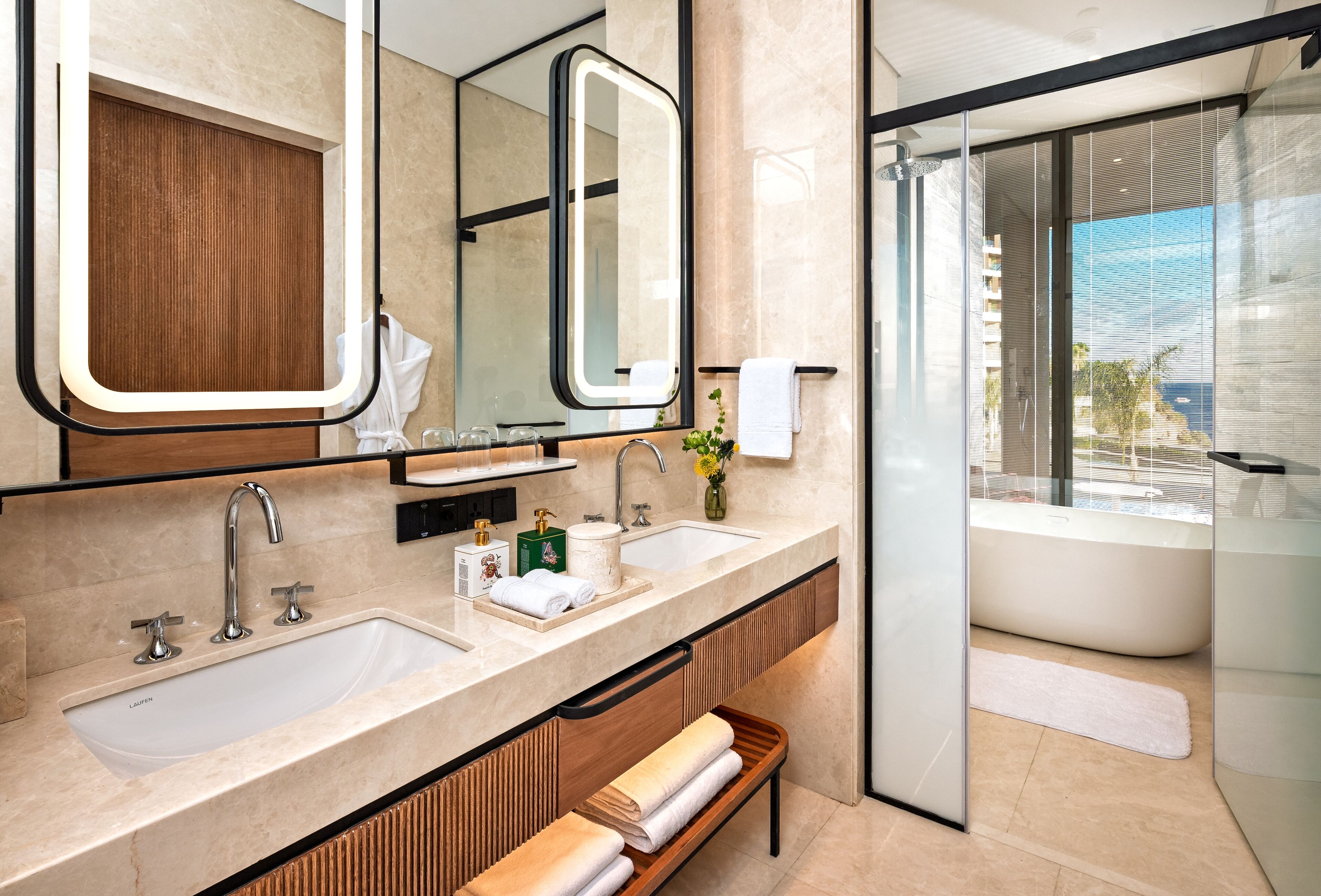 A modern bathroom with two sinks, a large mirror, and a glass-enclosed shower.