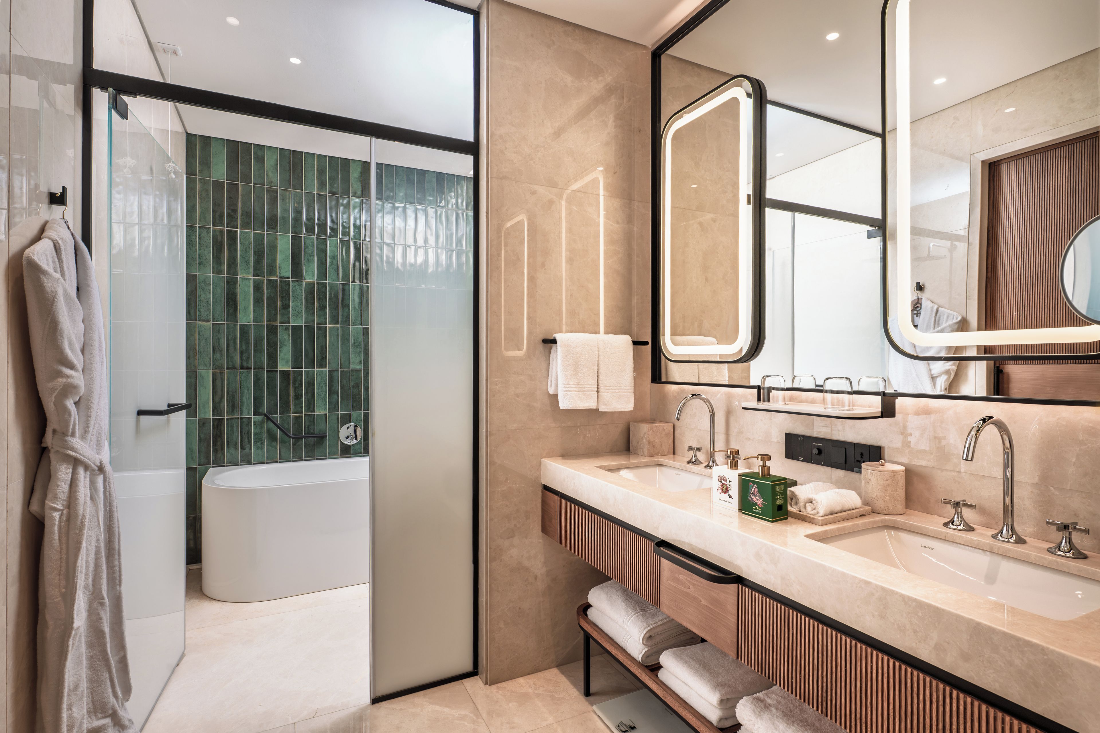 A modern bathroom with a glass shower enclosure, a freestanding bathtub, and a vanity with a large mirror.
