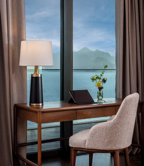A hotel room with a desk, a laptop, a lamp, and a vase with flowers. - Divan Talya (Antalya)