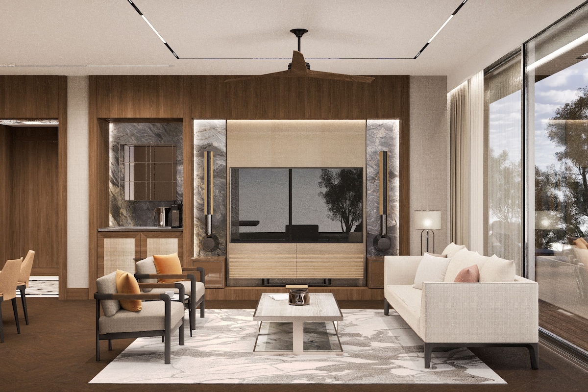 A modern living room with a sofa, chairs, a coffee table, and a large window with a view of trees.