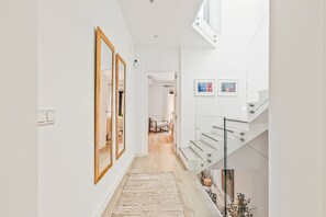 A modern interior with a staircase, a hallway leading to a room, and a view of a dining area. - Coral8 - Top modern townhouse in Estepona old town (Estepona)