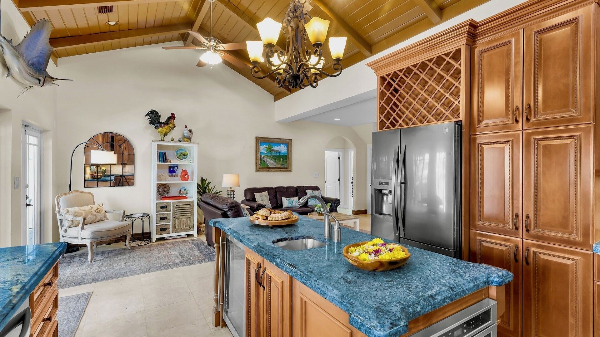 Una cocina amplia con una isla central, armarios de madera y un refrigerador de acero inoxidable.