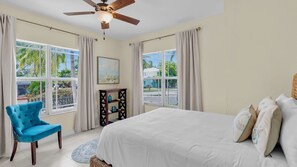 A bedroom with a bed, a chair, a ceiling fan, and large windows with curtains. - **LA BELLA CAPRI @ CASA MARINA** Estate & Pool + Last Key White Glove Service... (Key West)