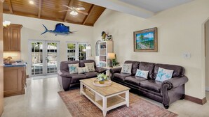 A spacious living room with two leather sofas, a coffee table, and a ceiling fan. - **LA BELLA CAPRI @ CASA MARINA** Estate & Pool + Last Key White Glove Service... (Key West)