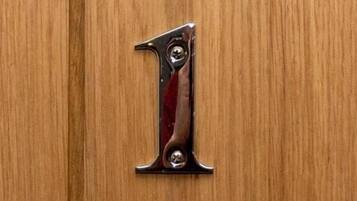 A wooden door with a metal number '1' handle.