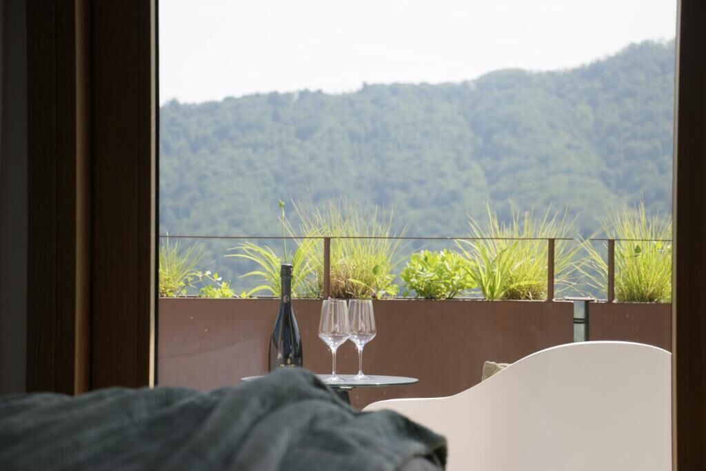 Parvekkeella on pöytä, kaksi viinilasia ja pullo.