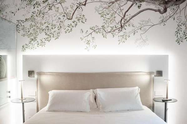 A bedroom with a large bed, two bedside tables, and a wall mural. - Borgo Capietaglio Wine Resort (Pontida)
