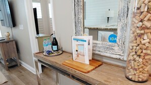 Un comptoir de cuisine avec une bouteille d’eau, une bouteille de vin et une boîte sur laquelle est écrit « BIENVENUE À LA MAISON ».