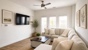 A living room with a sofa, a coffee table, a TV, and framed pictures on the wall. - View Prime Location Min To Pkwy, Dollywood, More 3 Bedroom Condo (Sevierville)