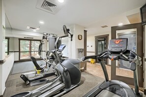 A gym with cardio machines, a treadmill, and a weight machine. - 8836 The Springs 1 Bedroom Condo (Keystone)