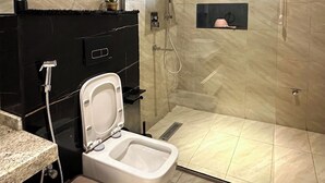 A modern bathroom with a glass-enclosed shower, a toilet, and a sink. - Vogue Hotel (Karu)