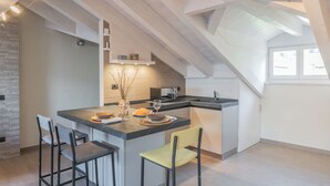 Una cocina moderna con una isla central, taburetes de bar y un comedor.