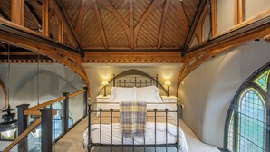 A bedroom with a wooden ceiling, a bed with white linens, two bedside lamps, and a window with a view. - Grade C Church in Cannich, Sleeps 2 w/ Parking (Beauly)