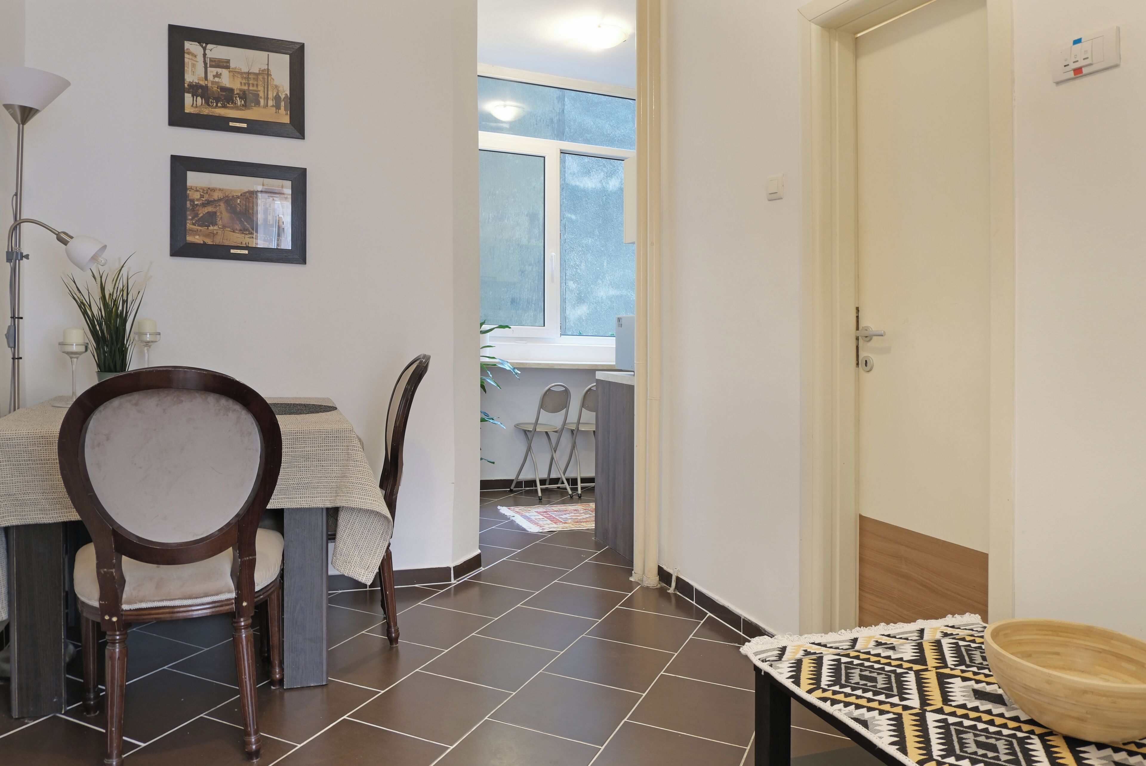Un espace repas comprenant une table, des chaises et donnant sur une autre pièce.