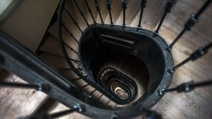 Eine Wendeltreppe mit Metallgeländern und Holzhinweisen.
