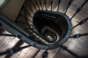 A spiral staircase with metal railings and wooden steps. - Cheese&Wine™ | Chiado - Rossio Square 1 (Lisboa)