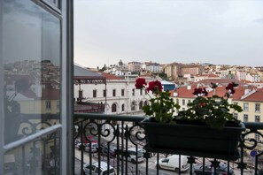 A balcony with a view of a cityscape, including buildings and parked cars. - Cheese&Wine™ | Chiado - Rossio Square 2 (Lisboa)